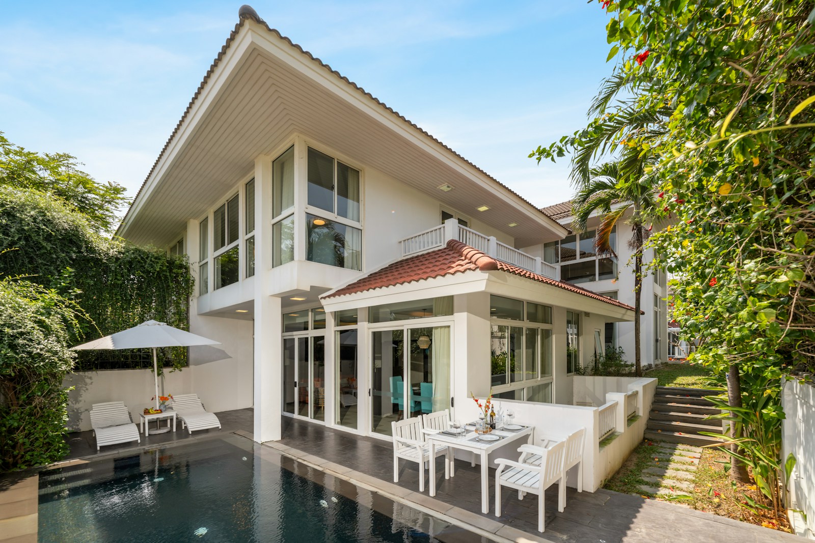 Photographie d’illustration d’une villa blanche avec piscine et terrasse aménagée